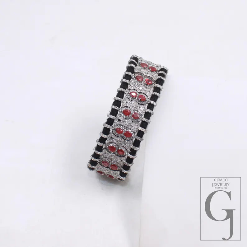 Bracelet with red gemstones and black accents on a white background, featuring the brand 'GEMCO JEWELRY'.