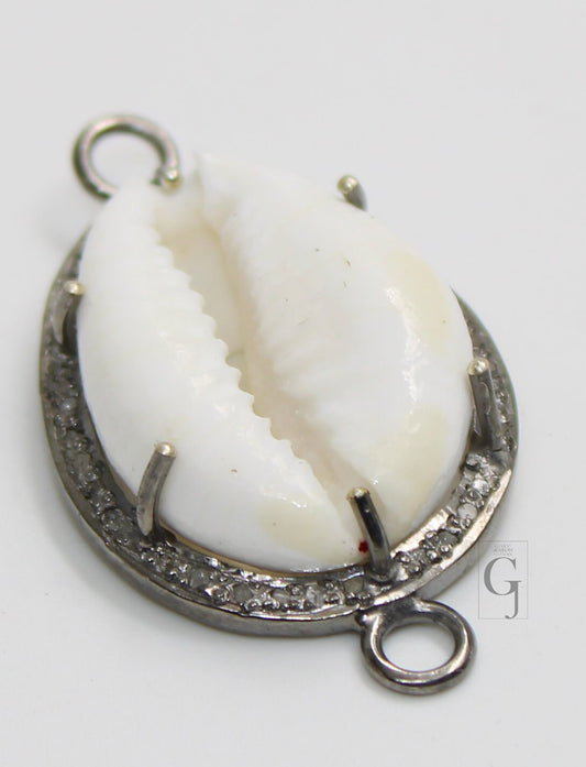 A sterling silver oxidised handmade diamond charm pendant featuring a cowrie design with pave diamonds around the edge.