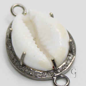 A sterling silver oxidised handmade diamond charm pendant featuring a cowrie design with pave diamonds around the edge.