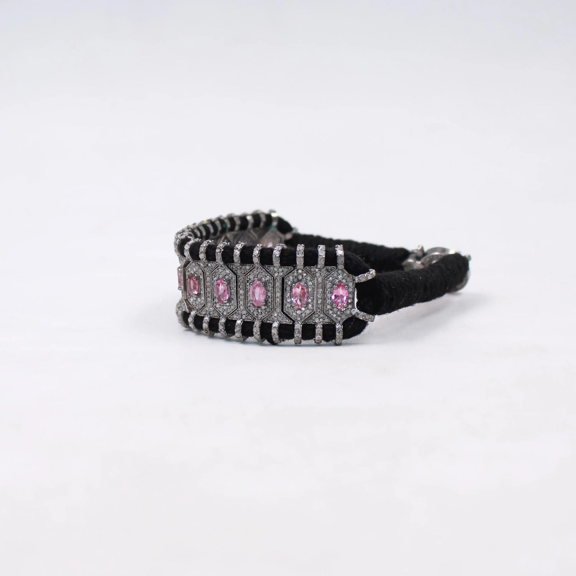 Black hair tie with pink and clear gemstones on a white background
