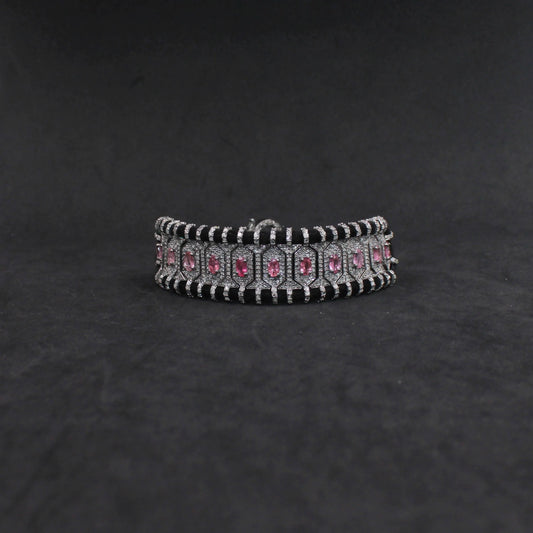 Silver bracelet with pink stones on a dark gray background