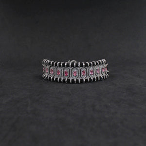 Silver bracelet with pink stones on a dark gray background